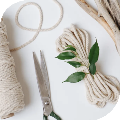 Macrame supplies including cord, scissors and driftwood.