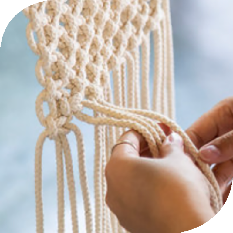 A partially knotted macrame wall hanging in progress.