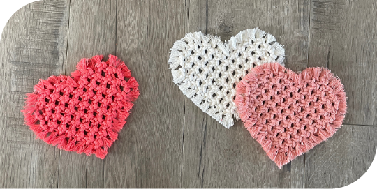 Macrame heart coasters in coral, salmon and white.