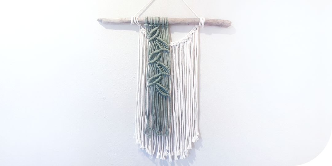 Macrame leaf wall hanging on driftwood.